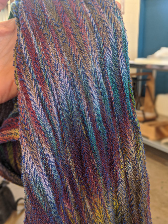 On the left Ellen is holding the painted warp shawl she wove (it took a long warping process to distribute the warp colors as you see them). On the right is a close up of her highly textured scarf, woven with 24 epi tencel warp and colcolastic weft in a twill.