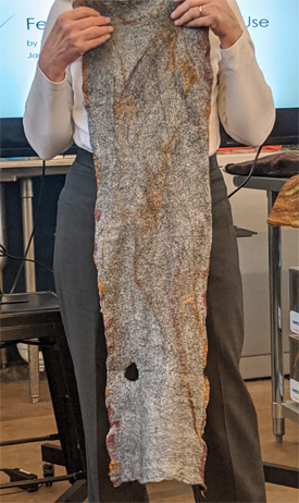 Suzy showed us two nuno felted scarves she had made and the decorative felted piece she is holding in the center photo. Each scarf has a hole for the wearer to pass one end of the scarf through to make it a ring.