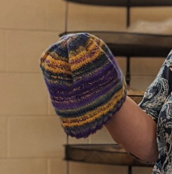 Jamie2Jamie showed us a hat she had knit with yarn she had fractal spun from painted roving, and she also brought five cotton towels she had woven in a false damask check pattern (Strickler 246). Four are in the background and she is holding her favorite.