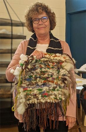Joyce wove her pillow top with a weft of many colors of roving and neckties.