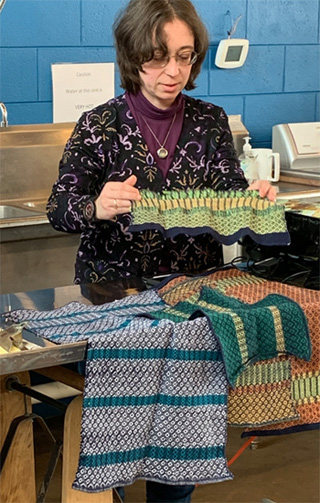 Mandy's cards challenged her to weave using yarn from the yellow 1/3 of the color wheel, with not less than 20 ends per inch, striped, mixed warp profile and overshot on opposites. She eliminated "overshot on opposites" and chose to use a mixed weft . The very handsomely patterned striped towels and sample above were Mandy's first 8-shaft projects. The sample she is holding and two of the towels are in shades of yellow and related colors in her mixed weft. She wove them all with with 8/2 cotton warp at 22 epi and used 8/2 cotton and bamboo in her weft.